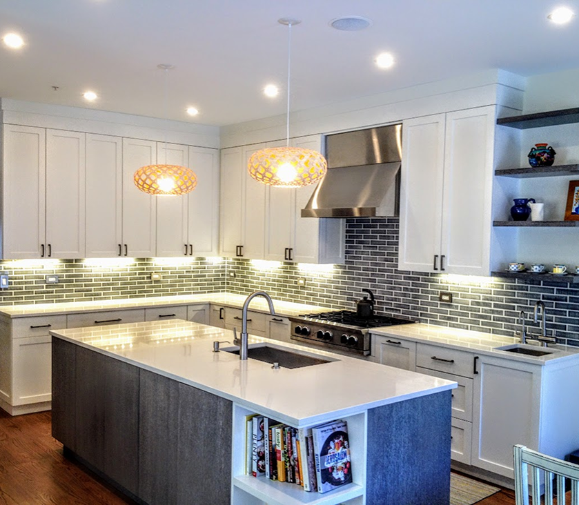 Completed kitchen installation with island and white cabinetry